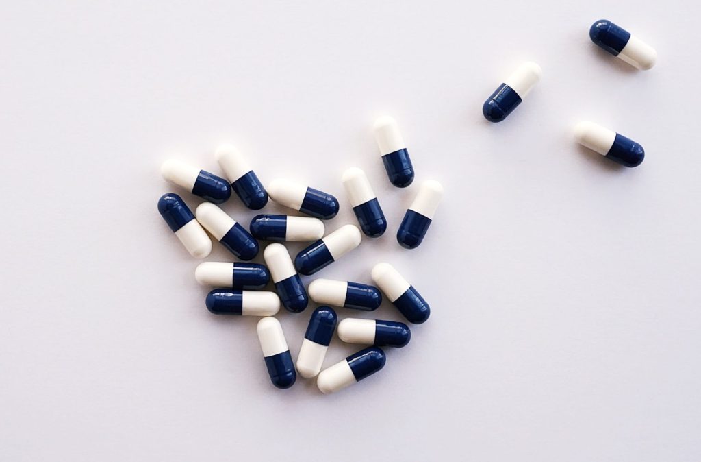 Blue and white pills on white background